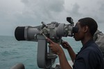 Logistics Specialist 3rd Class Norrik Hodge stands watch on the bridge wing of the littoral combat ship USS Fort Worth, Jan. 3, 2015. Fort Worth is currently on station conducting helicopter search and recovery operations as part of the Indonesian-led efforts to locate missing AirAsia Flight QZ8501.