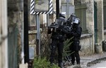 SWAT police officer patrol in the village of Longpont, north east of Paris, hunting down the two heavily armed brothers suspected in the massacre at Charlie Hebdo newspaper, Thursday, Jan.8, 2015.