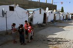 In this June 29, 2014 file photo, Syrian refugee children play outside their tent in a Syrian refugee camp in the eastern town of Marj, Bekaa valley, Lebanon.