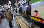 A man watches a television broadcasting a news about detained two Japanese, at an electronics store in Tokyo, Tuesday, Jan. 20, 2015.