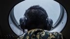 A member of the search team looks out over the waters of the Java Sea, on 30 December 2014