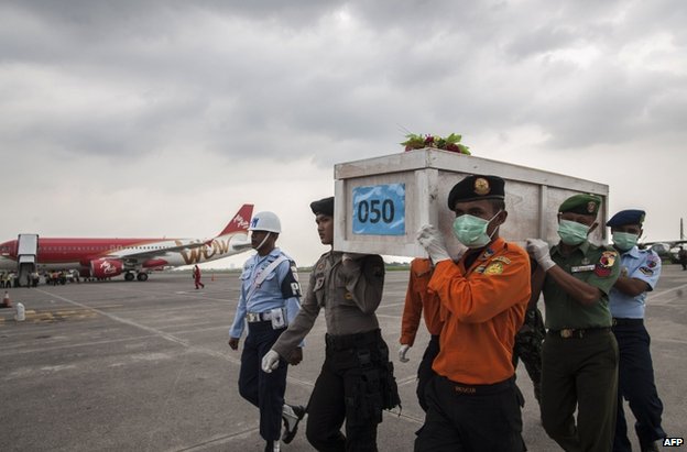 Indonesian personnel carry a coffin at Surabaya airport, 19 January