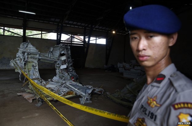 A policeman guards fuselage debris inside a storage facility at Kumai port in Pangkalan Bun, 19 January