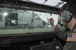 File - Lt. Kellen Odom, assigned to Helicopter Maritime Strike Squadron 35, makes a note on the window of the ship's helicopter control room to track aircraft operations as an HSM 35 helicopter prepares to take off from the flight deck of the guided-missile destroyer USS Sampson in the Java Sea assisting with Indonesian-led search efforts for Air Asia flight QZ8501, 3 January, 2014.