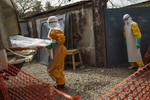 Burial teams of volunteers in Guinea, wearing full personal protective equipment and working in teams of seven, carrying the body of a 40 year-old woman who died from the Ebola virus from the MSF Treatment Center at Donka Hospital to the Conakry Cemetary for a safe burial, 17 January, 2014.