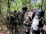 File - In this photo of Thursday April 19, 2012 Ugandan soldiers hunting for Joseph Kony and members of the Lord's Resistance Army walk through the jungle near River Vovodo, Central African Republic.