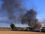 Smoke rises from a military base after a plane crash in Albacete, Spain, Monday, Jan. 26, 2015. A Greek F-16 fighter jet crashed into other planes on the ground during NATO training in southeastern Spain Monday, killing at least 10 people.