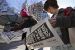 Passersby read extra newspapers in Tokyo reporting about an online video that purported to show an Islamic State group militant beheading Japanese journalist Kenji Goto, Sunday morning, Feb. 1, 2015.