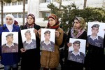 Anwar al-Tarawneh, center, the wife of Jordanian pilot, Lt. Muath al-Kaseasbeh, who is held by Islamic State group militants, holds a poster of him with Arabic that reads, "we are all Muath," during a protest in Amman, Jordan, Tuesday, Feb. 3, 2015.