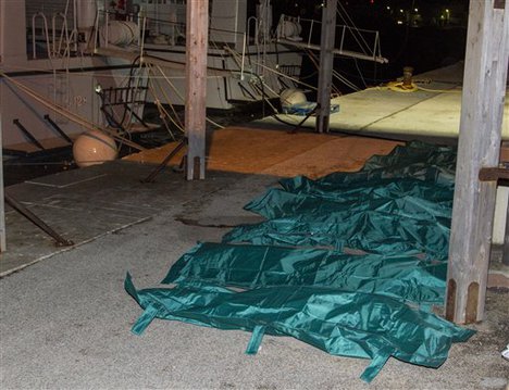 Bodies are lined up in the harbor of Lampedusa Monday, Feb. 9, 2015. At least 29 migrants have died from hypothermia while traveling from North Africa to Italy aboard a smuggler's life raft in heavy seas, amid a surge of migrants making the dangerous sea crossing despite the harsh winter conditions.