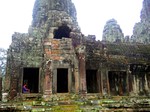 A lady sits by one of the windows in an old Angkor temple in Siem Reap.