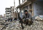 File - In this picture taken Friday, Jan. 30, 2015, a Syrian Kurdish sniper sits among the rubble in the Syrian city of Ain al-Arab, also known as Kobani, Syria.