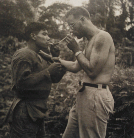 Harvard botanist Richard Evans Schultes and an Amazonian medicine man, snorting  curare powder through bones. Curare, a plant-derived poison most often used to lethal effect on hunting darts and arrows, is also capable of producing psychedelic states of consciousness.