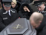 Boris Nemtsov's mother Dina Eidman, center, relatives and friends stand at the coffin during a burial ceremony at Troekurovskoye cemetery in Moscow, Russia, Tuesday, March 3, 2015.