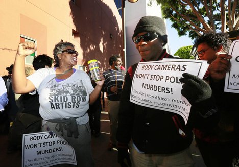 Suzette Shaw, left, a homeless woman, joins others protesting a police shooting of a homeless man on Tuesday, March 3, 2015, in downtown Los Angeles.