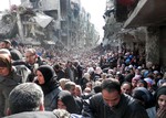 In this Jan. 31, 2014, file photo, released by the United Nations Relief and Works Agency for Palestine Refugees in the Near East (UNRWA), shows residents of the besieged Palestinian camp of Yarmouk, queuing to receive food supplies, in Damascus, Syria.