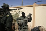 File: Malian soldiers inspect vehicles and arms recovered from Islamist militants.