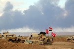 In this Wednesday, March 4, 2015 photo, smoke rises as the Iraqi army, supported by volunteers, battles Islamic State extremists outside Tikrit, 80 miles (130 kilometers) north of Baghdad, Iraq