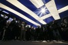 Protesters hold a giant Greek national flag during an anti-austerity and pro-government demonstration in front of the parliament in Athens February 15, 2015. Picture taken February 15, 2015.  To match Insight EUROZONE-GREECE-GERMANY-INSIGHT/ REUTERS/Alkis Konstantinidis  (GREECE - Tags: POLITICS BUSINESS CIVIL UNREST)