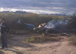 A man stands near one of two helicopters that crashed near Villa Castelli in the La Rioja province of Argentina, Monday, March 9, 2015.