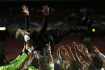 Real's coach Carlo Ancelotti, reacts as he is lived into the air by his players