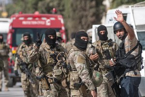 File - Tunisian soldiers celebrate at the end of a successful raid against gunmen in the Oued Ellil suburb of Tunis, Tunisia, Friday, Oct. 24, 2014. Tunisian authorities stormed the home of suspected militants to end a 24-hour standoff.