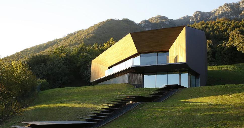 Alpine Villa Cleverly Uses Hillside to Form a Giant Wood Clad Courtyard