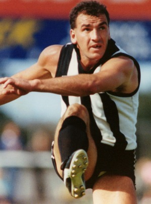 One of the great Darrens: Darren Millane launches the ball forward for Collingwood.