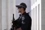 An AFP officer armed with an SR-16 stands guard to the front of Parliament House in Canberra in October. 