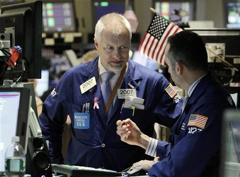 In this Nov. 1, 2010 photo, Thomas Bishop, left, talks with a fellow specialist on the floor of the New York Stock Exchange, Monday, Nov. 1, 2010.