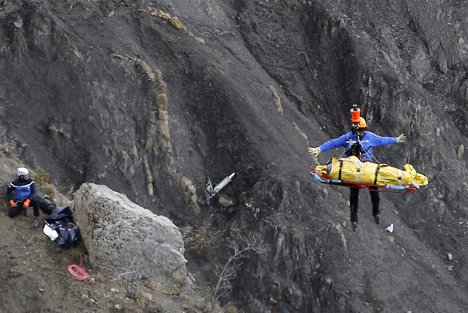 In this Thursday March 26, 2015 file photo a rescue worker is lifted into an helicopter at the Germanwings crash site near near Seyne-les-Alpes, France.