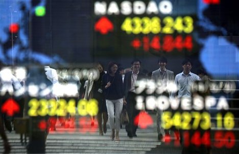 Pedestrians are reflected on an electronic stock board of a securities firm in Tokyo