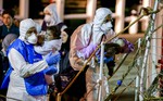 Rescuers help children to disembark in the Sicilian harbor of Pozzallo, Italy, early Monday, April 20, 2015. About 100 migrants, including 28 children, were rescued on Sunday by a merchant vessel in the Sicilian Strait.