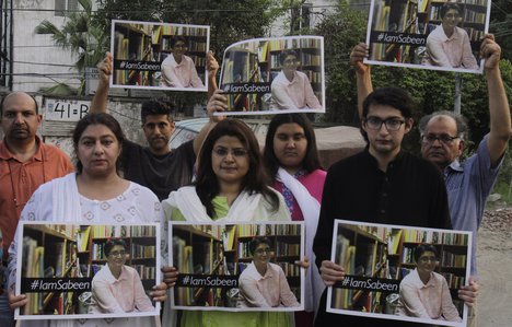 Members of the social group "Umeed Jawan Peace Society" hold pictures of prominent women's rights activist Sabeen Mahmud, who was killed by unknown gunmen, during a demonstration to condemn her killing, Saturday, April 25, 2015, in Lahore, Pakistan.