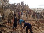 Volunteers help with rescue work at the site of a building that collapsed after an earthquake in Kathmandu, Nepal, Saturday, April 25, 2015.