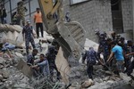 Nepal's security personnel remove debris from a budget hotel that collapsed in Saturday’s earthquake, in Kalanki neighbourhood of Kathmandu, Nepal, Sunday, April 26, 2015.