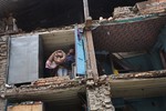 A resident carries his belongings retrieved from the ruins of his home after Saturday's earthquake in Bhaktapur, Nepal, Tuesday, April 28, 2015.