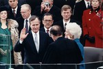 File - Chief Justice William Rehnquist administering the oath of office to President George H. W. Bush during Inaugural ceremonies at the United States Capitol. January 20, 1989.