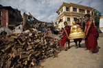 Buddhist monks salvage a statue of a Buddhist deity from a monastery around the famous Swayambhunath stupa after it was damaged by Saturday's earthquake in Kathmandu, Nepal, Thursday, April 30, 2015.