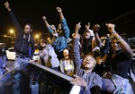 Demonstrators celebrate the announcement of six officers charged in the police-custody death of Freddie Gray before a curfew goes into effect Friday, May 1, 2015, in Baltimore.