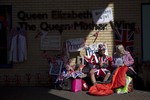 Royal fans Terry Hutt, aged 79, and Margaret Tyler, 71, with their Union flag designed outfits, flags and banners wait on a bench across the street from the Lindo Wing of St Mary's Hospital in London, Monday, April 27, 2015.