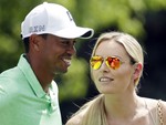 Lindsey Vonn speaks to Tiger Woods during the Par 3 contest at the Masters golf tournament Wednesday, April 8, 2015, in Augusta, Ga. (AP Photo/Charlie Riedel)