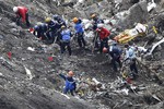 In this March 26, 2015 file photo, rescue workers work on debris of the Germanwings jet at the crash site near Seyne-les-Alpes, France. The co-pilot of Germanwings Flight 4525 tried a controlled descent on the previous flight that morning to Barcelona before the plane crashed into a mountainside in March on its way back to Germany