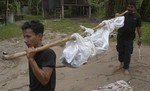 Thai rescuers carry a dead body to hospital in Songkhla province, southern Thailand, Friday, May 1, 2015. Authorities found an isolated mountain shelter that is believed to be a trafficking camp for ethnic Rohingya Muslims fleeing Myanmar.