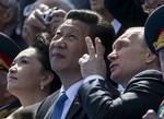 Russian President Vladimir Putin, right, gestures while speaking with Chinese President Xi Jinping, second left, watching the Victory Parade marking the 70th anniversary of the surrender of Nazi Germany in World War II, in Red Square, Moscow, Russia, Saturday, May 9, 2015.