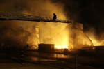 Firefighters battle a blaze, Monday, April 27, 2015, after rioters plunged part of Baltimore into chaos, torching a pharmacy, setting police cars ablaze and throwing bricks at officers.