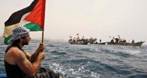 Vittorio waves the Palestinian flag on a boat off the coast of Gaza.