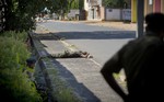 Soldiers loyal to President Pierre Nkurunziza look at the body of a dead soldier who they said was killed because he belonged to the faction supporting the attempted coup