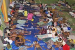 Migrants sleep on the floor at a sports stadium that was turned into a temporary shelter in Lhoksukon, Aceh province, Indonesia, Tuesday, May 12, 2015.