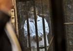 File - In this Tuesday, Jan. 28, 2014 photo, Egypt's ousted President Mohammed Morsi stands inside a glassed-in defendant's cage during his trial on charges related to the prison breaks at the height of the 18-day 2011 uprising against his predecessor Hosni Mubarak.